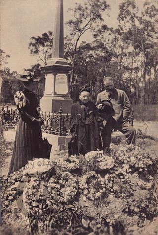 Three mourners at a graveside