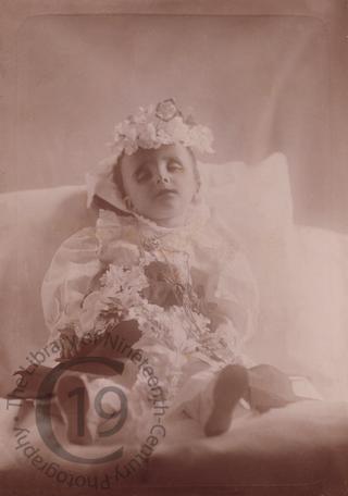 A small boy covered with flowers