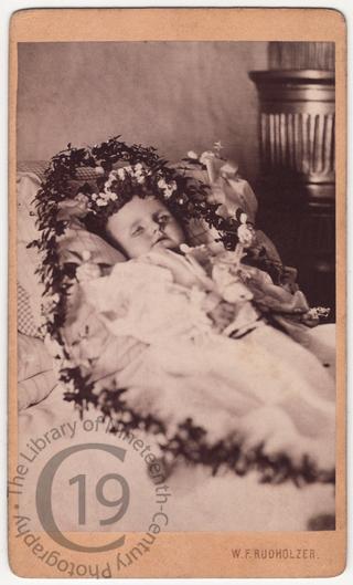An infant wreathed in flowers