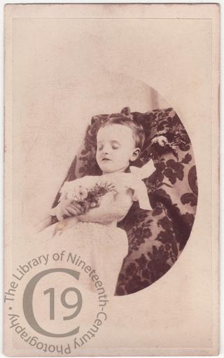 An infant with a posy of wildflowers 