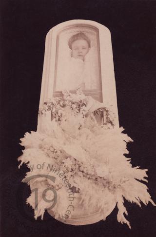 Woman in glass-topped coffin