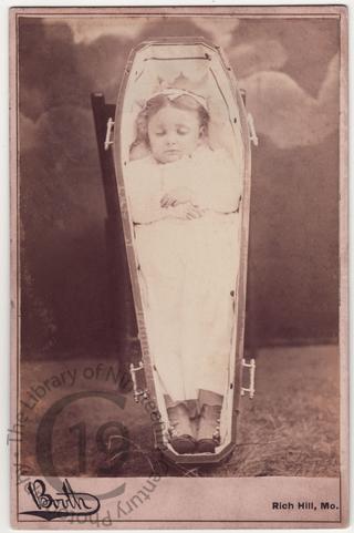 Girl in propped-up coffin