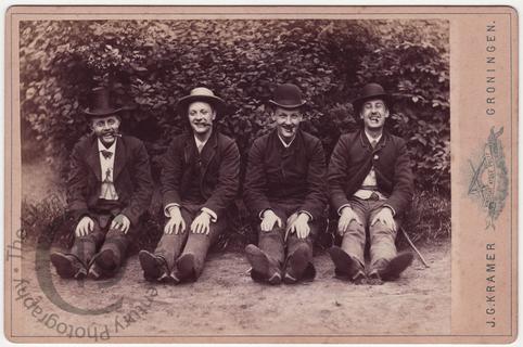 Four laughing men with cigars