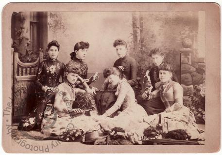 Seven young women eating bananas
